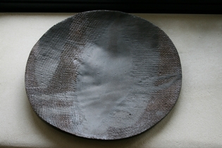 A grey and red ceramic plate.